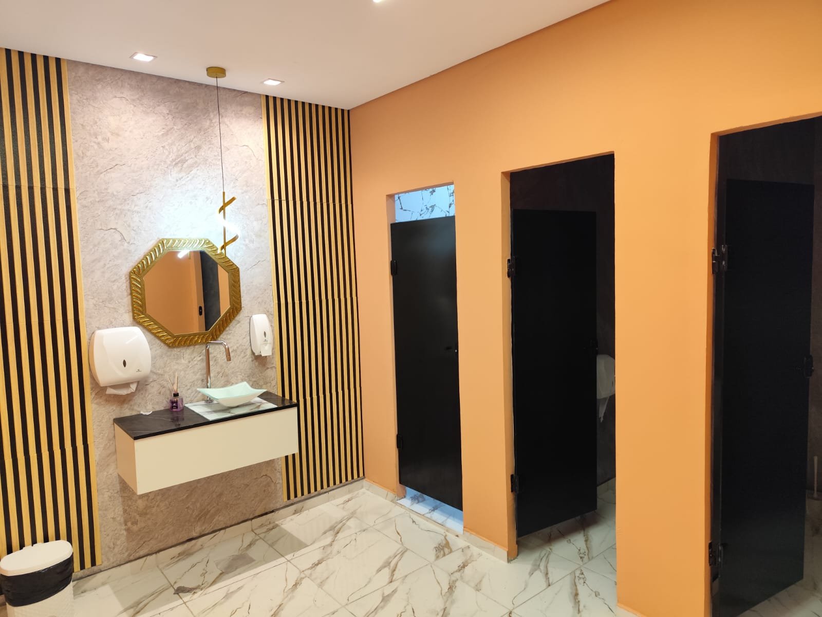Vestiário com cabines individuais e bancada com espelho